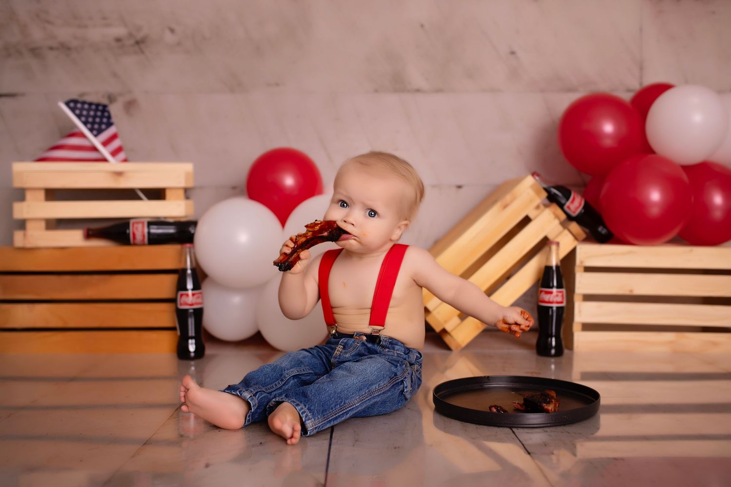 A baseball themed first birthday cake smash setup with decorative balloons and ONE letters.