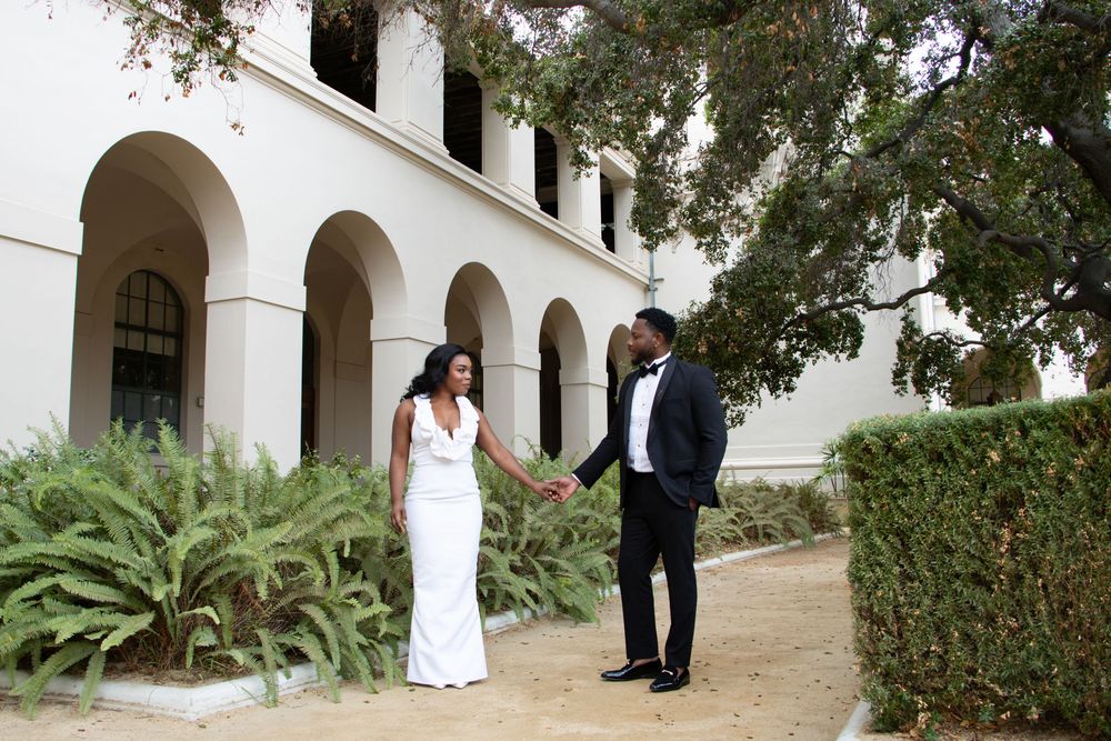 Romantic photoshoot in front of a beautiful white Spanish colonial building with arches.