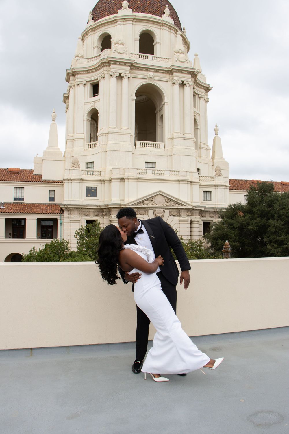 Dancing couple photographed with elegant white domed building in background.
