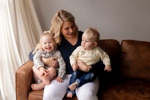 A series of heartwarming family portraits showing tender moments between parents and young children in a neutral studio setting.