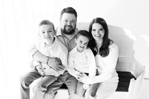 Black and white family portrait against white background.