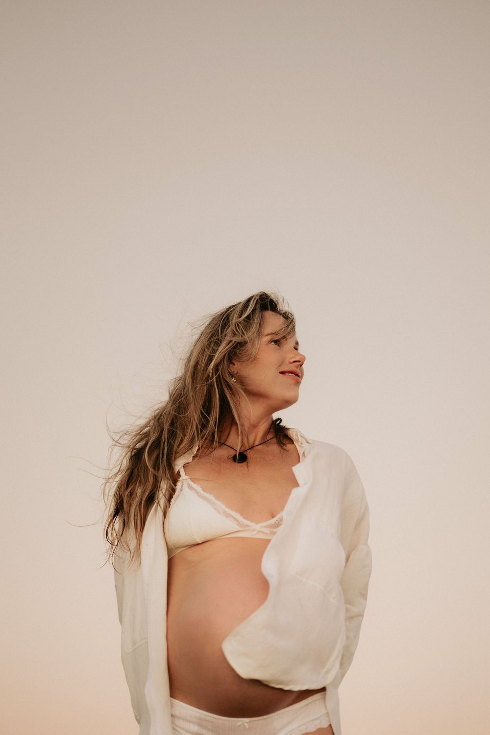 A woman in a white shirt dances expressively against a beige background, creating a dynamic motion sequence.