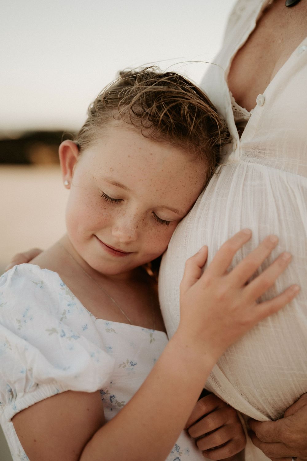 A series of tender moments showing a young child resting against soft white bedding in a warm, natural light setting.