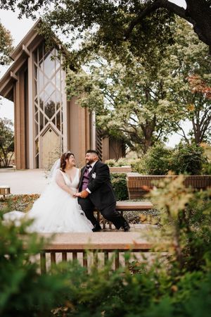 Romantic wedding photos taken outside a modern chapel surrounded by trees.