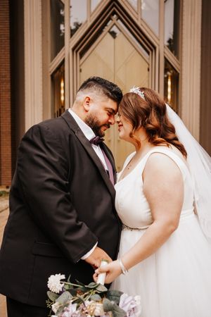 Romantic moments captured outside a chapel with architectural details.