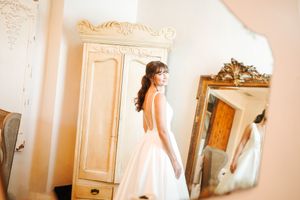Elegant bridal preparation scene in a light-filled room with vintage mirrors.