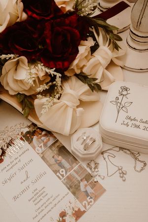 Wedding invitation suite with deep red florals and elegant calligraphy on white paper.