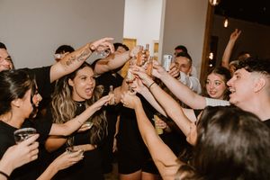 Wedding reception dance floor filled with guests celebrating with raised arms.