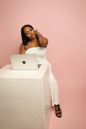 Modern business portrait with laptop on white platform against pink backdrop. at Vanessa Charlotte Photography studio
