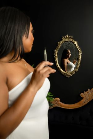 Artistic reflection portrait with ornate gold mirror and decorative elements. at Vanessa Charlotte Photography studio