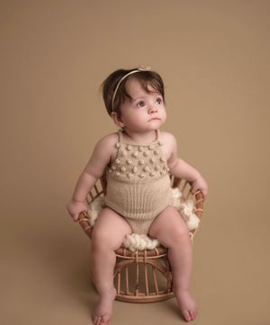 Classic baby portrait in NYC, featuring a crochet romper and neutral tones for an elegant, timeless style.