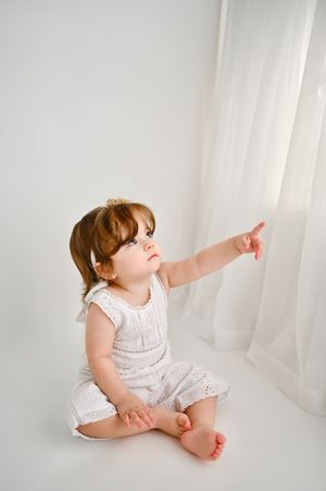 Natural light milestone baby portrait in Brooklyn, NY, with a soft, airy setting and minimalist white styling.