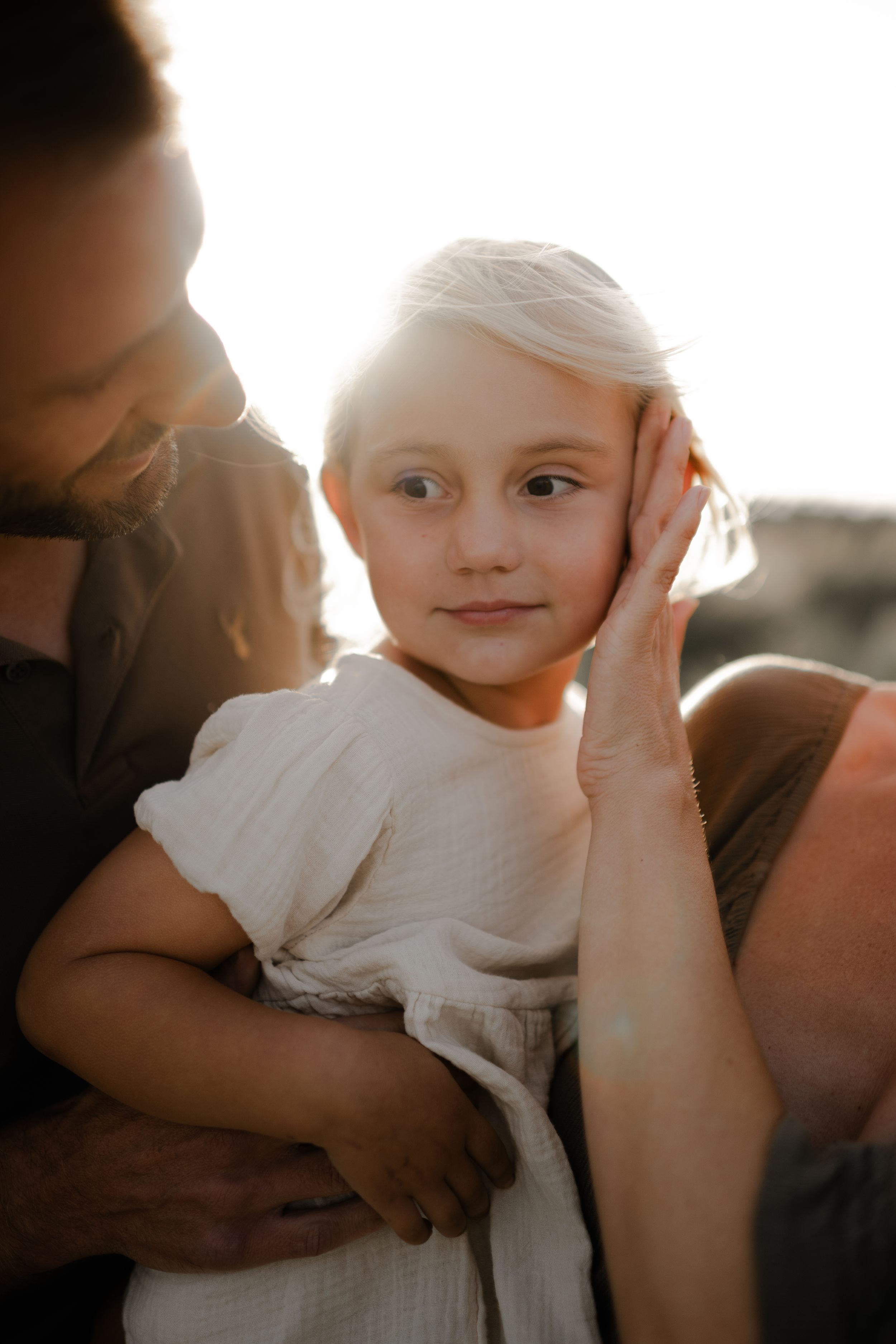 A little girl in her parents arms