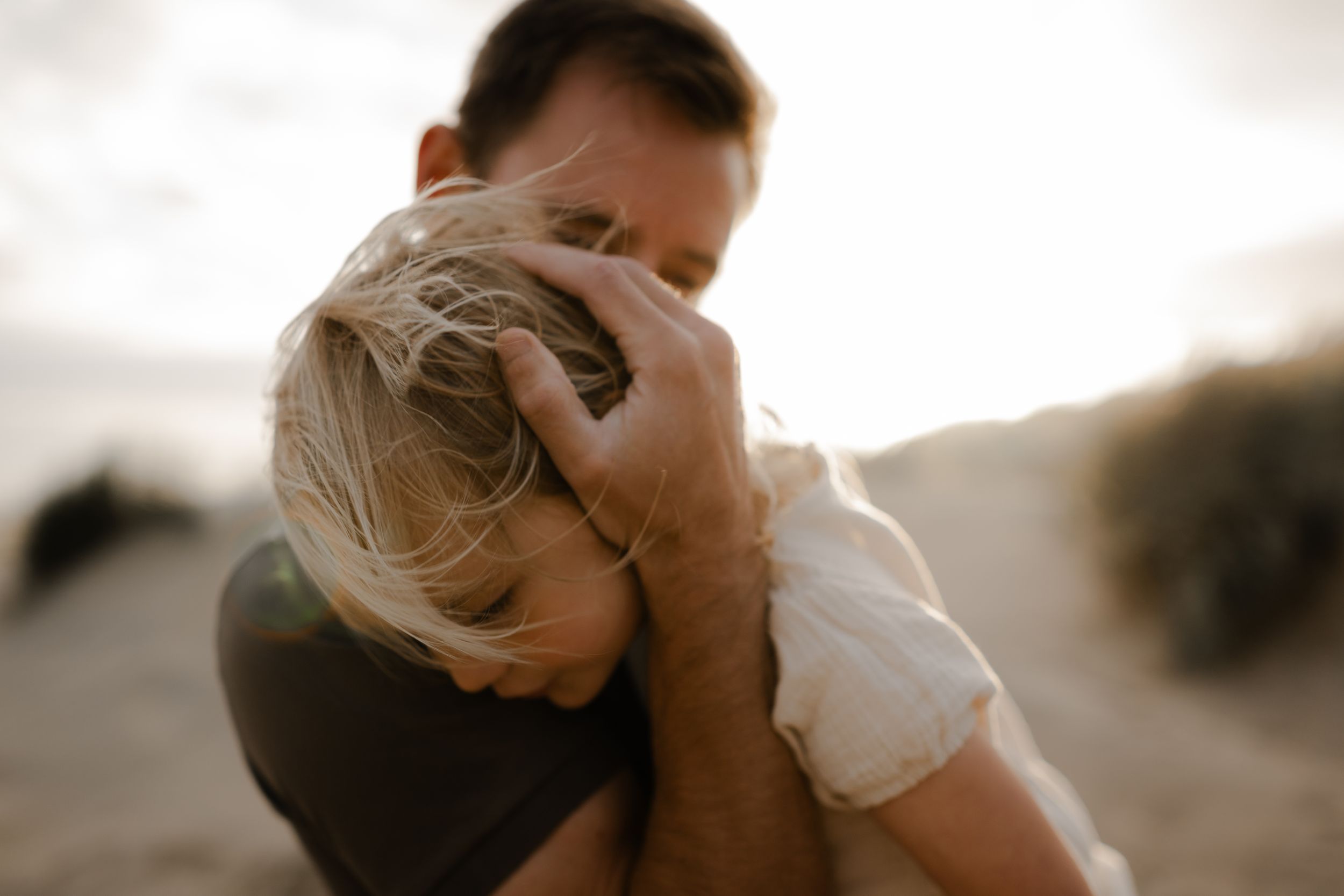 a father gently embracing his young daughter during a photo session in Kent