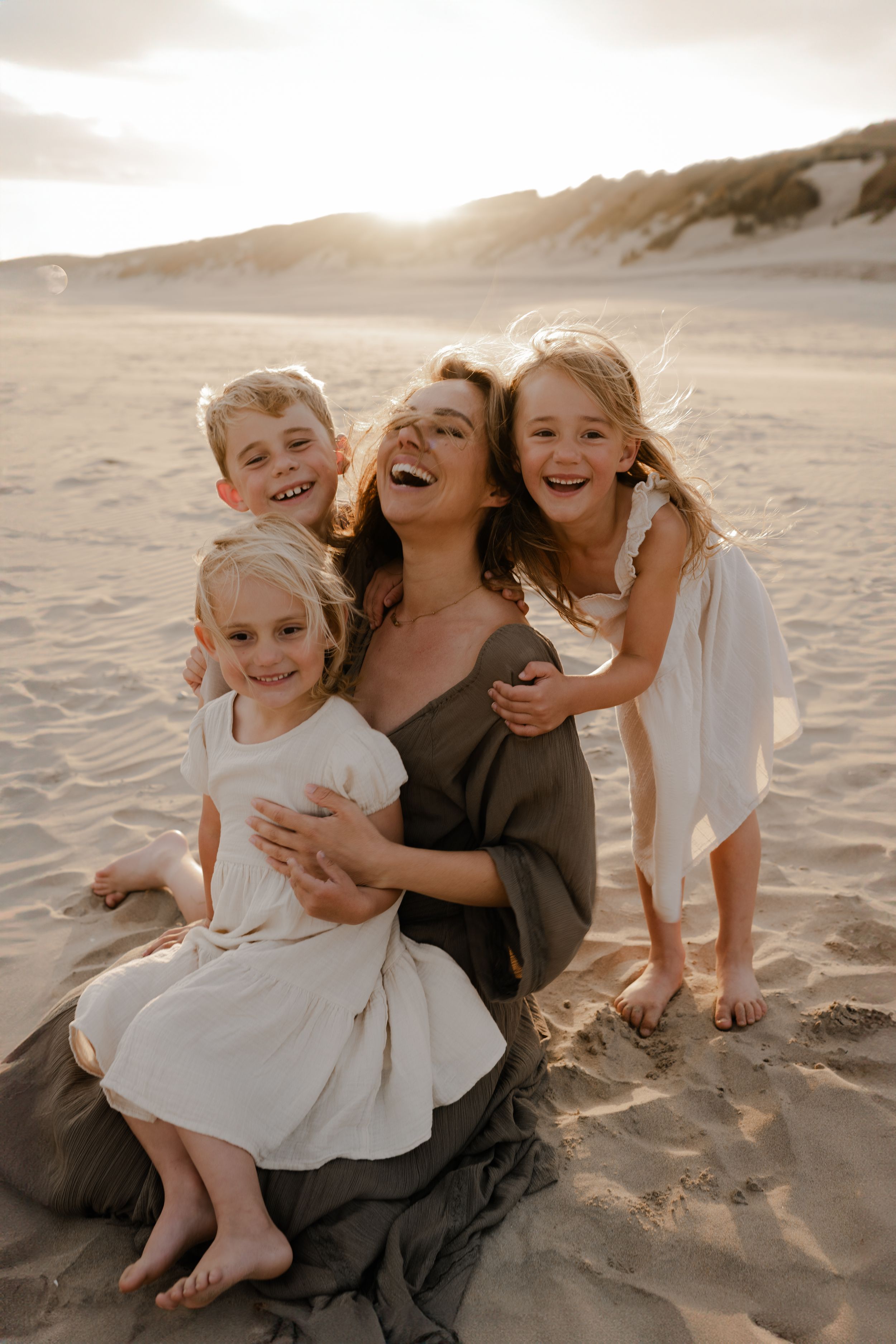 a mother surrounded by her kids is laughing during a photo session in Kent