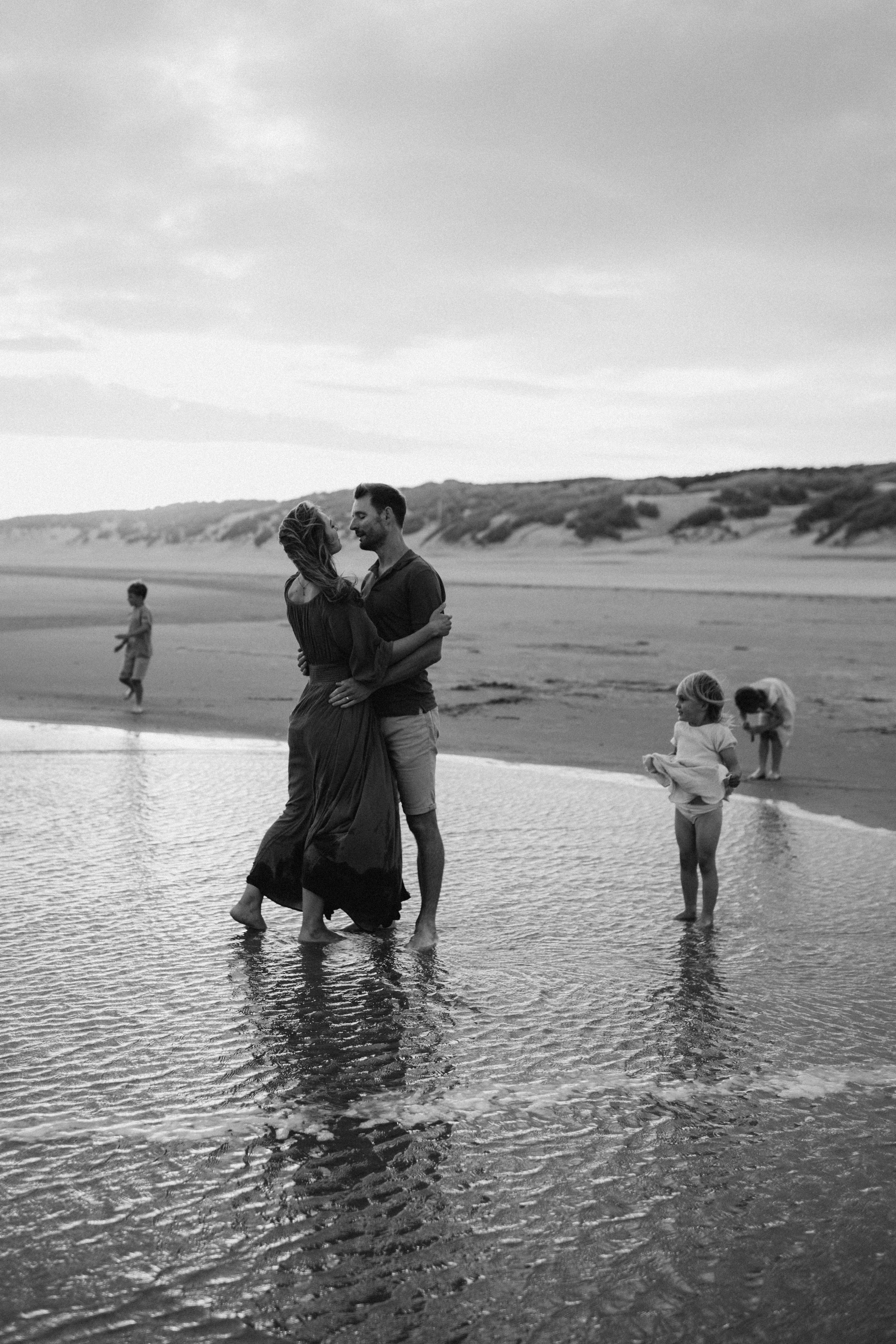 a family captured in a candid photo on the beach during a photo session in Kent