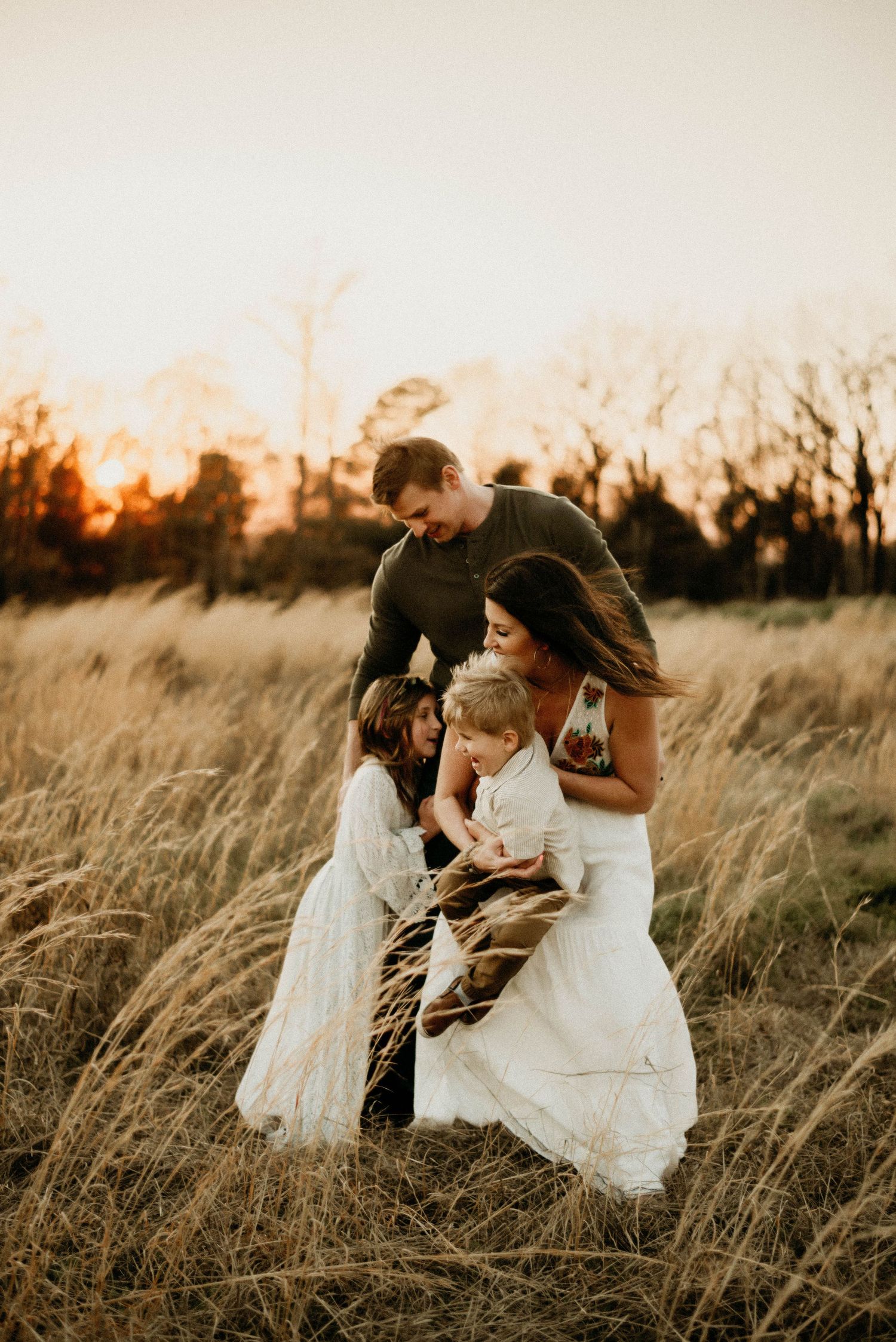 Family portrait session in rustic field during sunset.