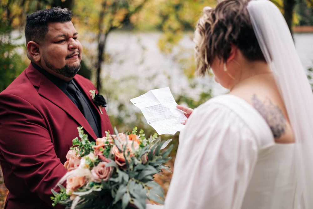 A wedding ceremony exchange with fall colors and a lake in the background.
