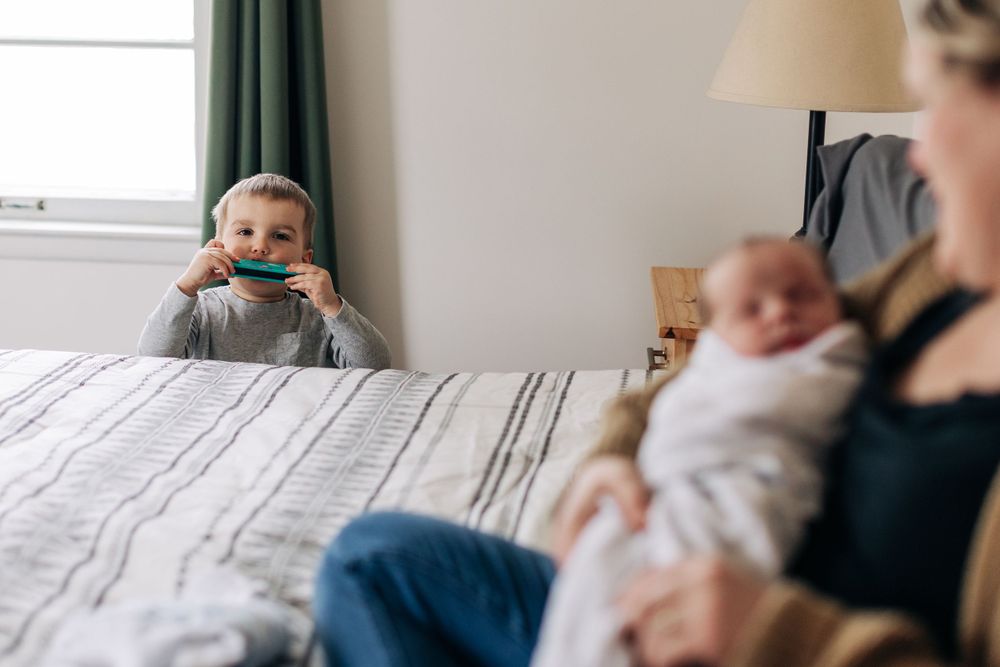 Cozy bedroom scene with children and soft natural light from window.