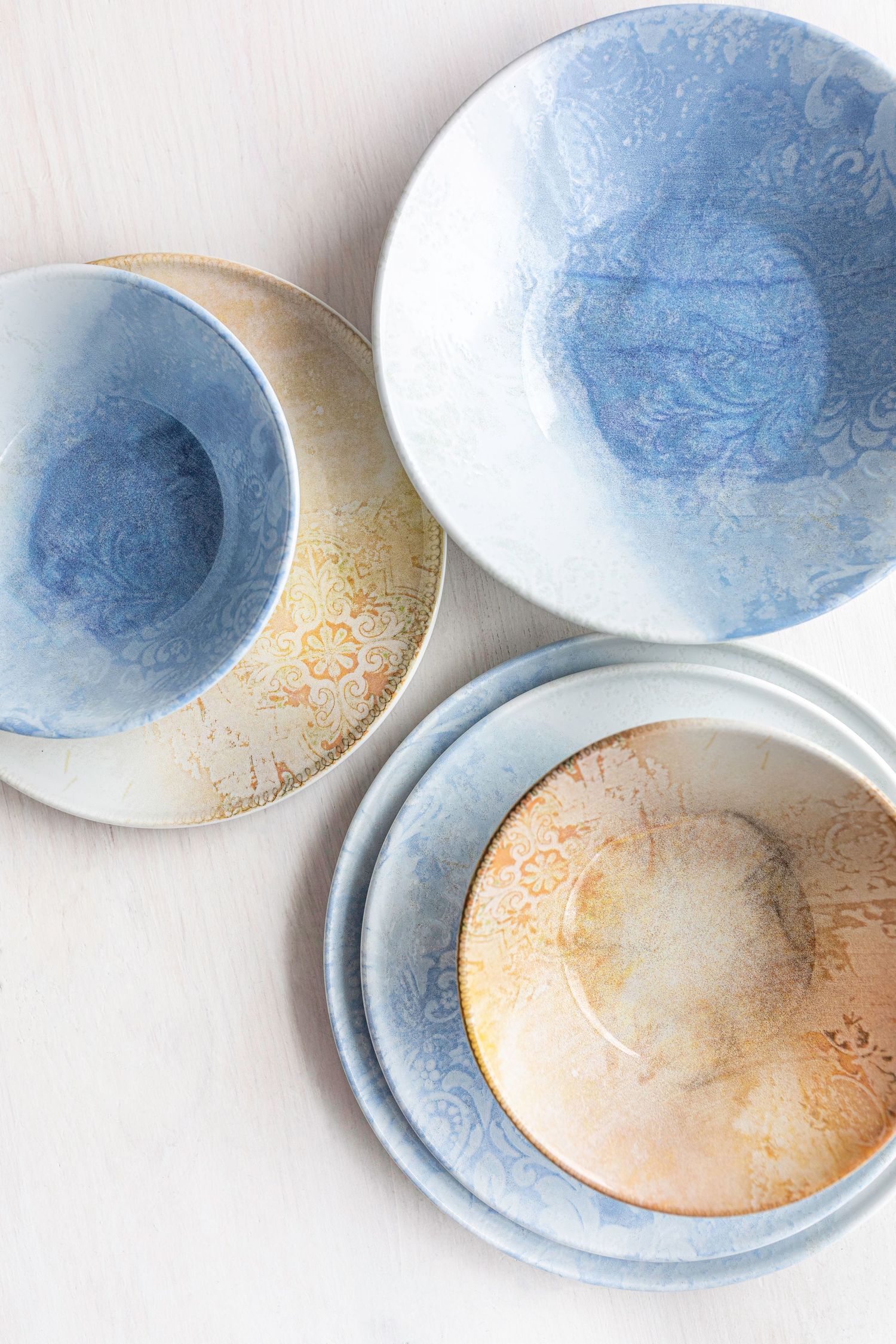 Porcelain plates and bowls from the Loren collection with digitally printed designs in blue and gold tones.