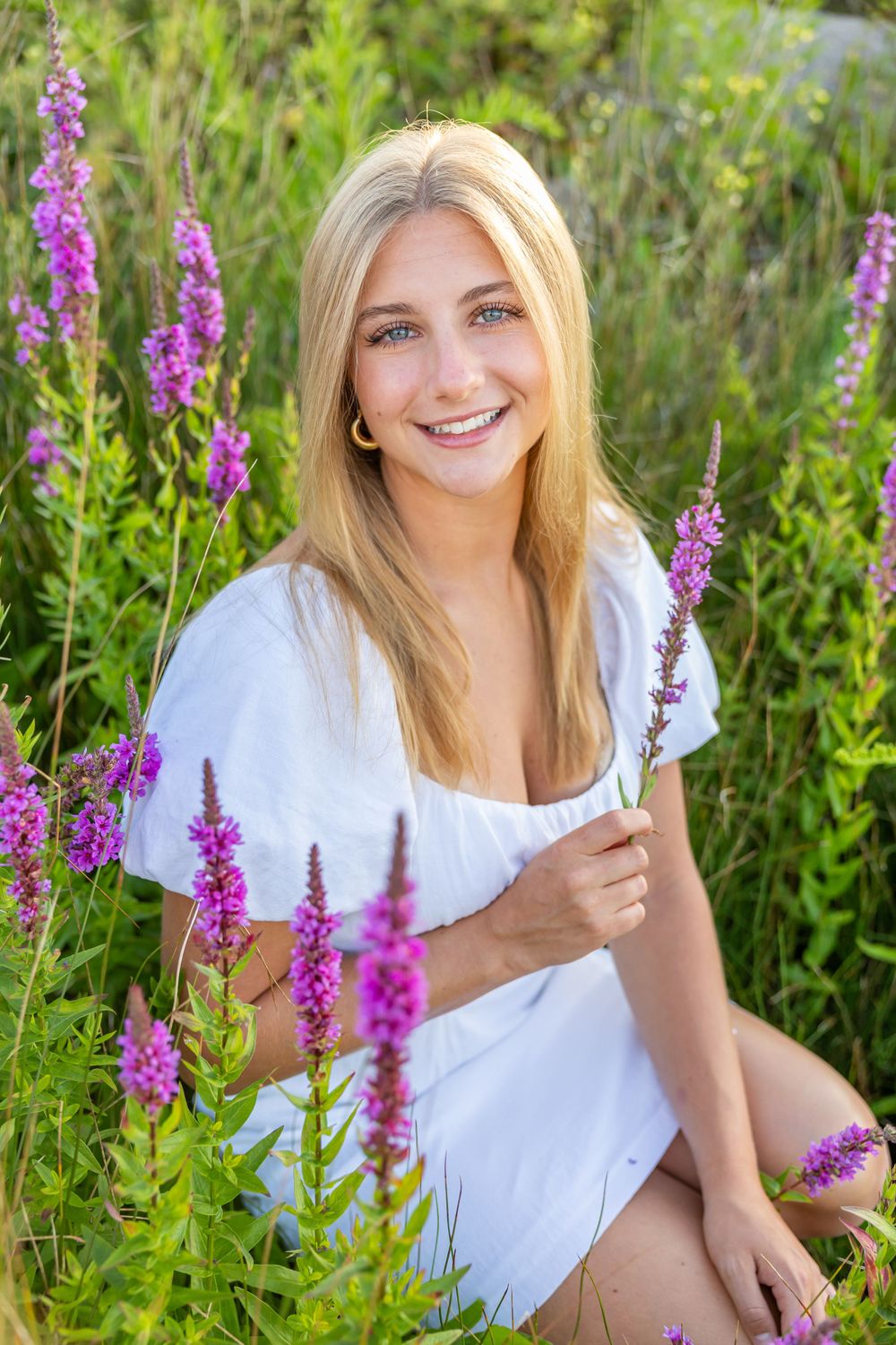 A portrait in a field of purple wildflowers with blooming liatris spikes.