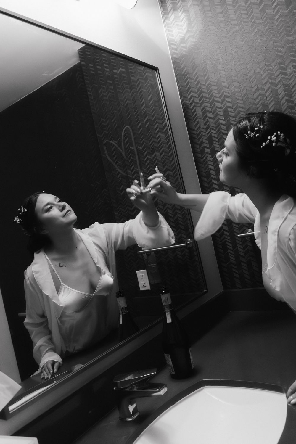 Bride writing on bathroom mirror with lipstick