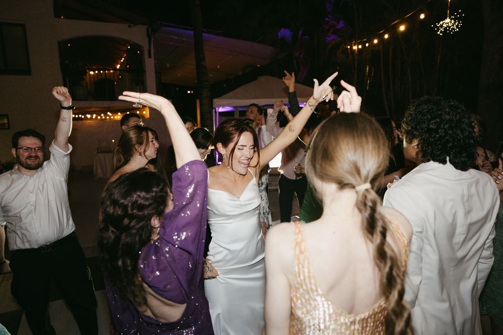 Fun wedding reception photo of bride dancing with guests at the Manor at St. Lucie Crescent.