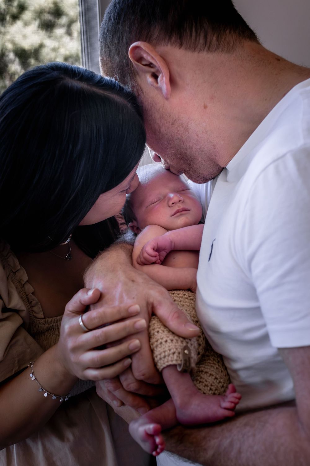 Parents sharing an intimate moment with their newborn baby.