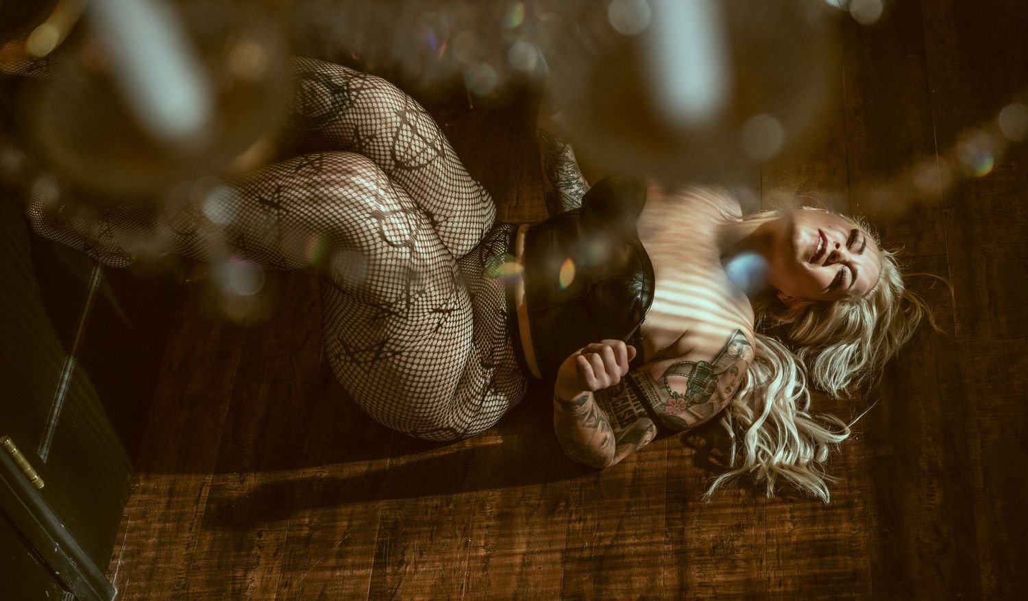 Artistic overhead boudoir shot with lace details and bokeh lighting effects.