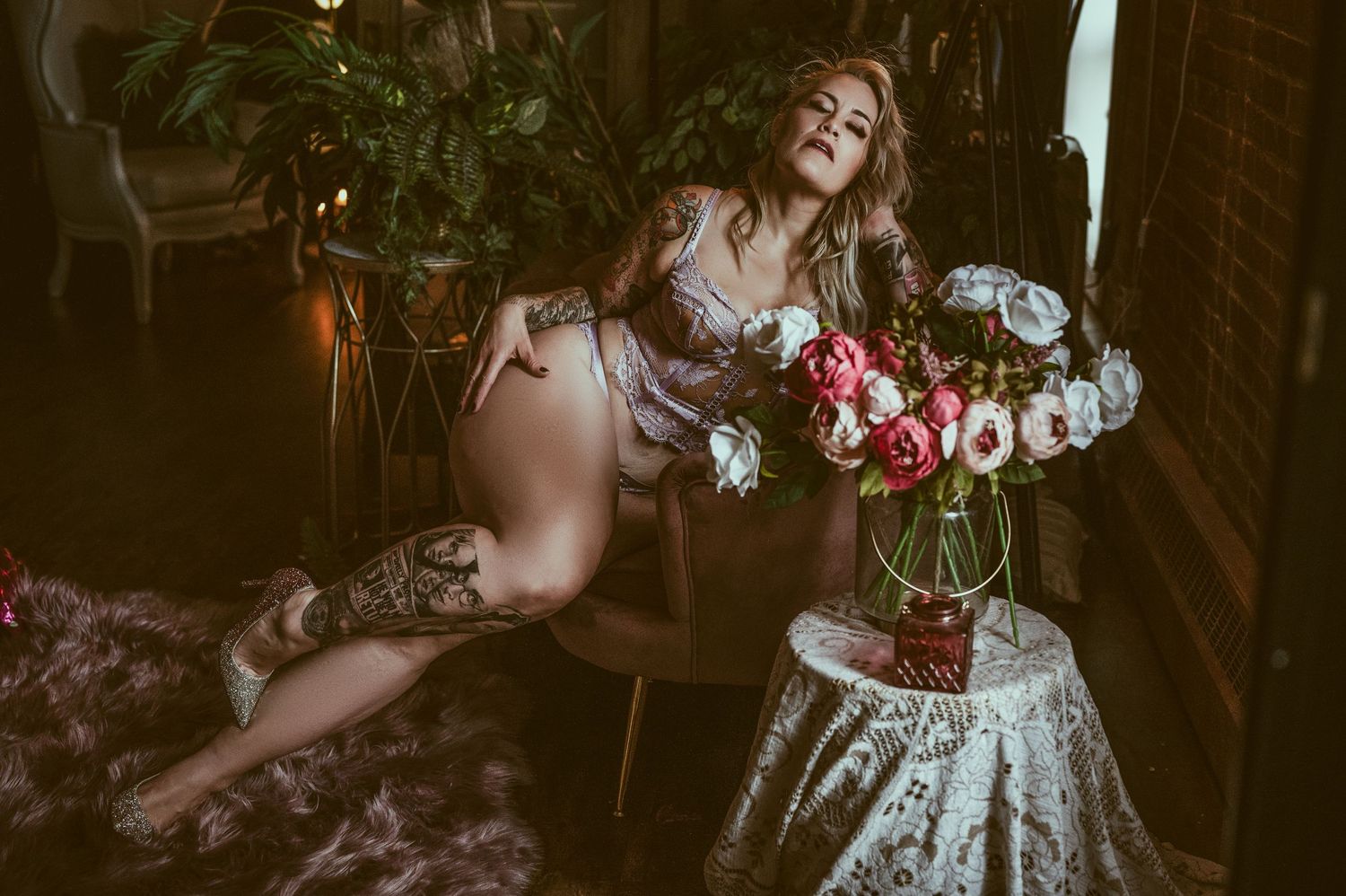 Romantic boudoir scene with flowers and soft lighting creating a dreamy atmosphere.