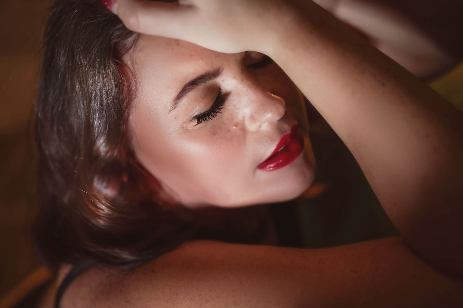 Close-up boudoir portrait with classic makeup and vintage-inspired styling.