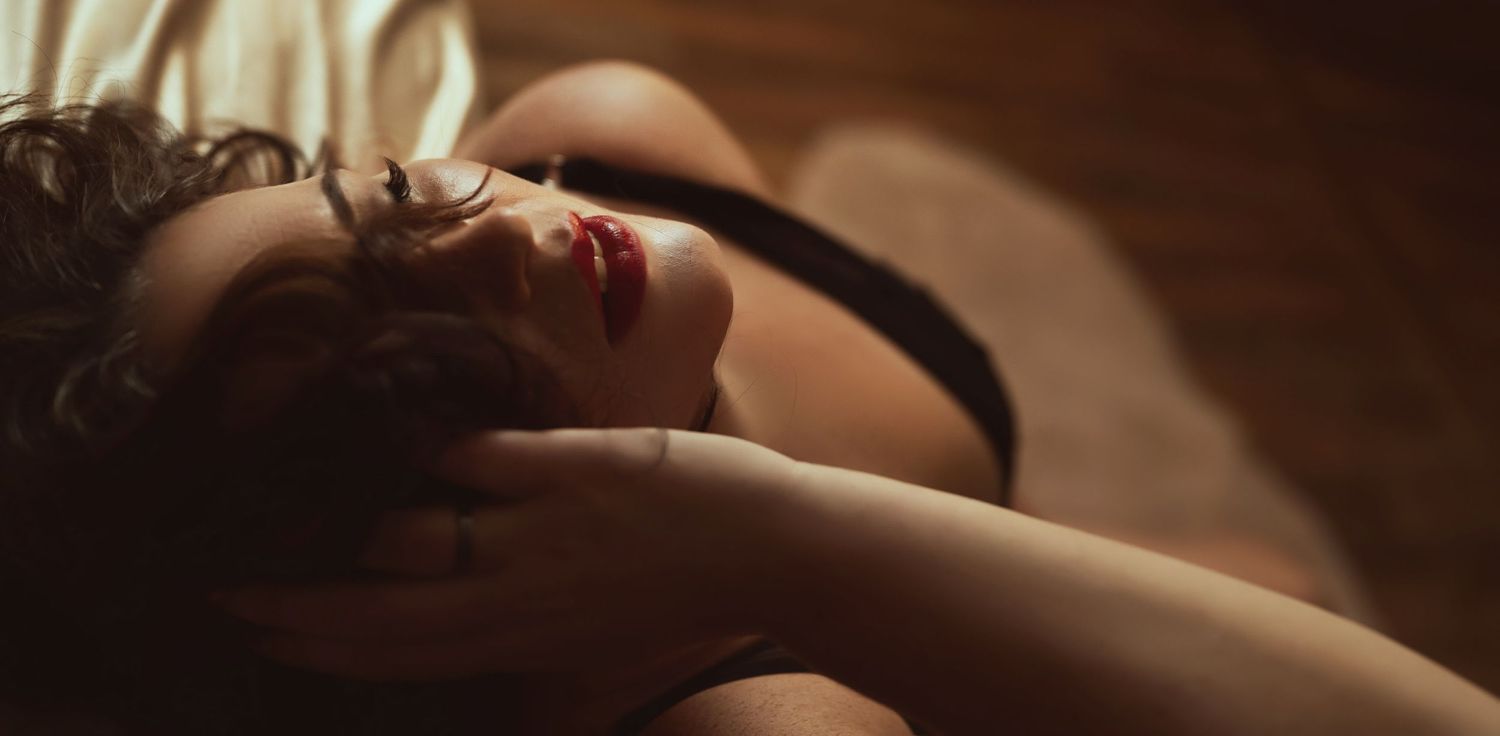 Atmospheric boudoir photography with dramatic side lighting creates romantic mood.