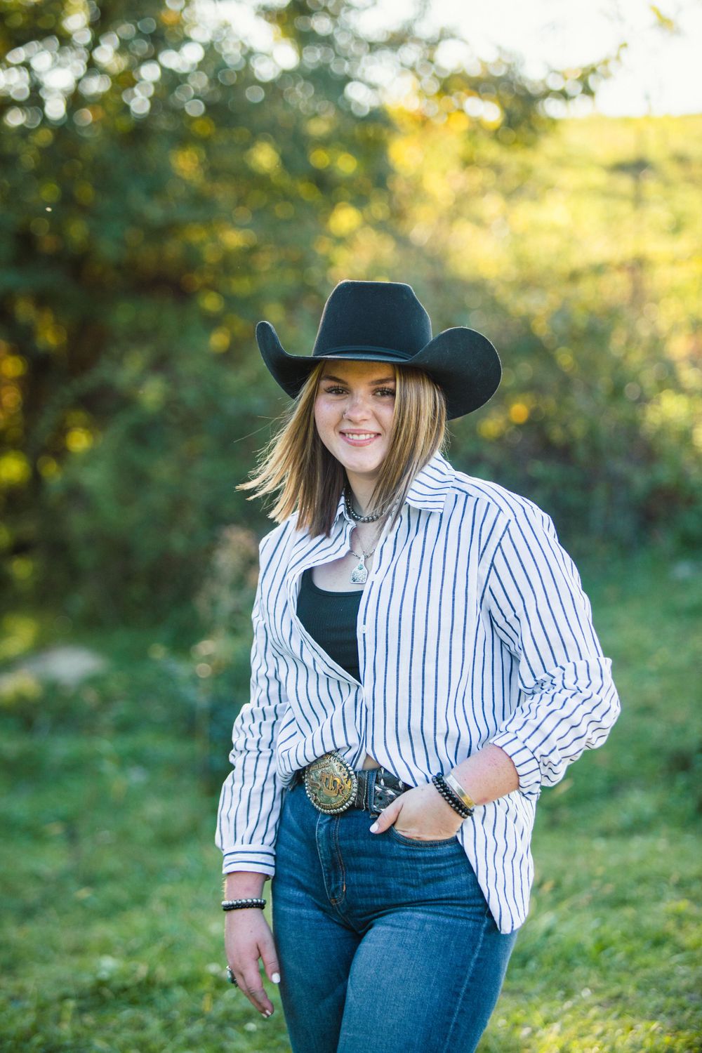 Western style portrait in a grassy field with autumn colors.