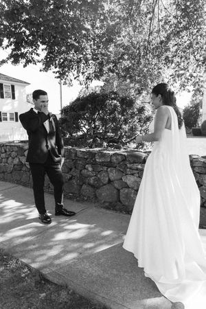 Black and white photo of a groom emotional seeing his bride for the first time on their wedding day outdoors.