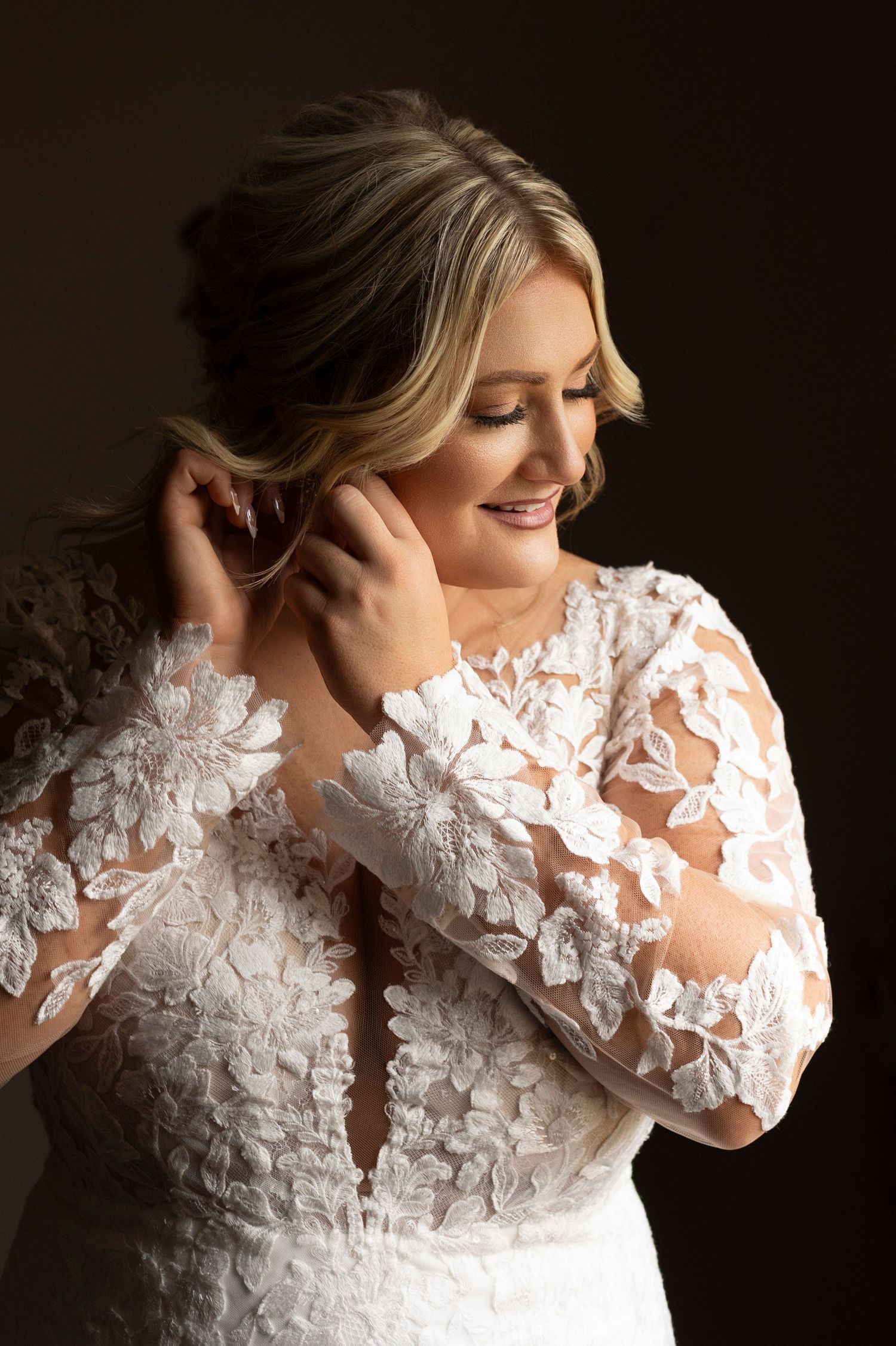 Beautiful lace wedding dress with sheer floral applique sleeves and elegant neckline detail.