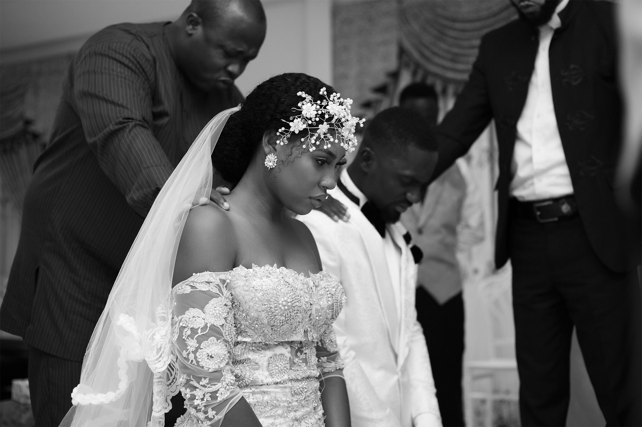 Black and white wedding photograph showing bride in lace dress and floral headpiece.