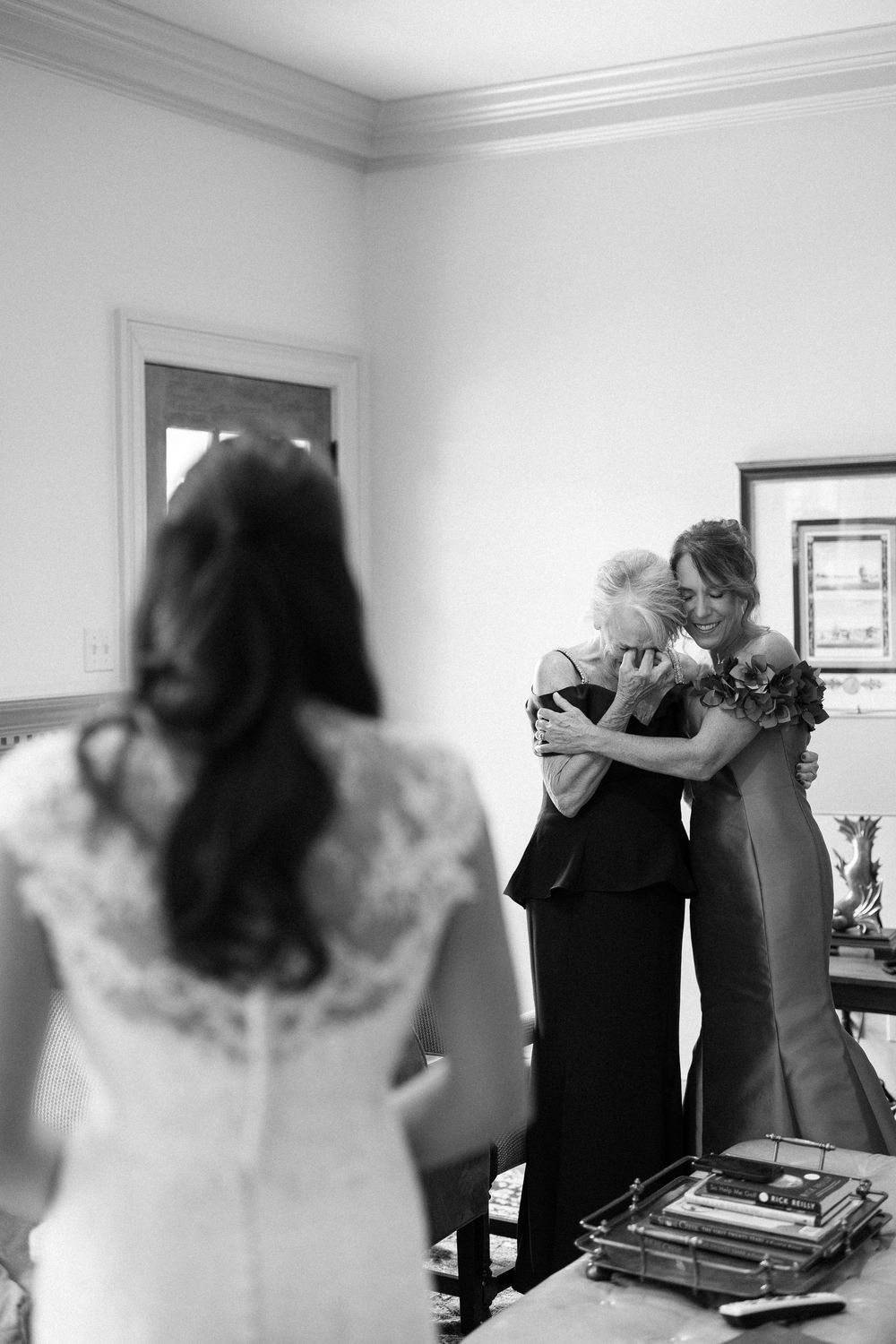 A series of emotional black and white wedding photos showing intimate moments between family members embracing.