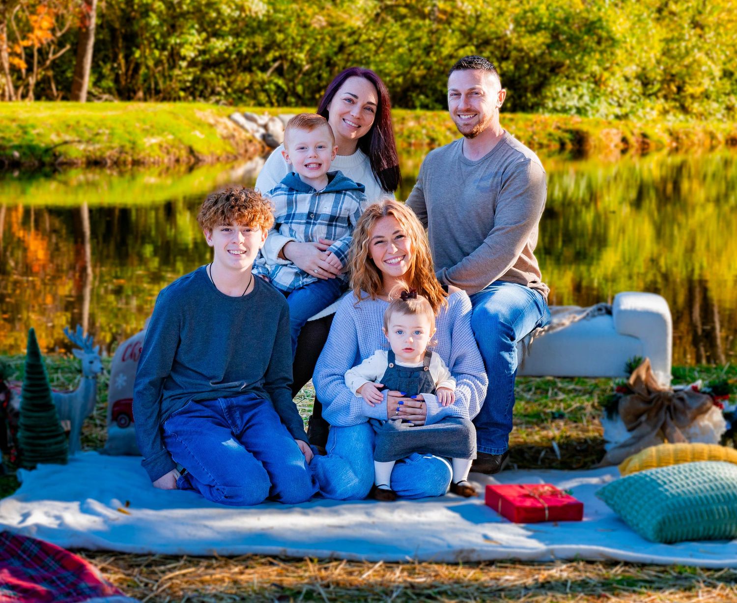 Family portrait session at sunset in a rustic field with warm autumn colors.