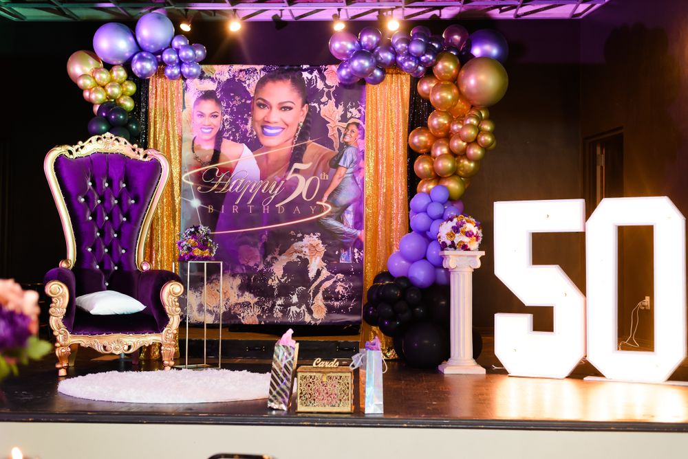 Party venue decorated with large light-up numbers and purple mood lighting.