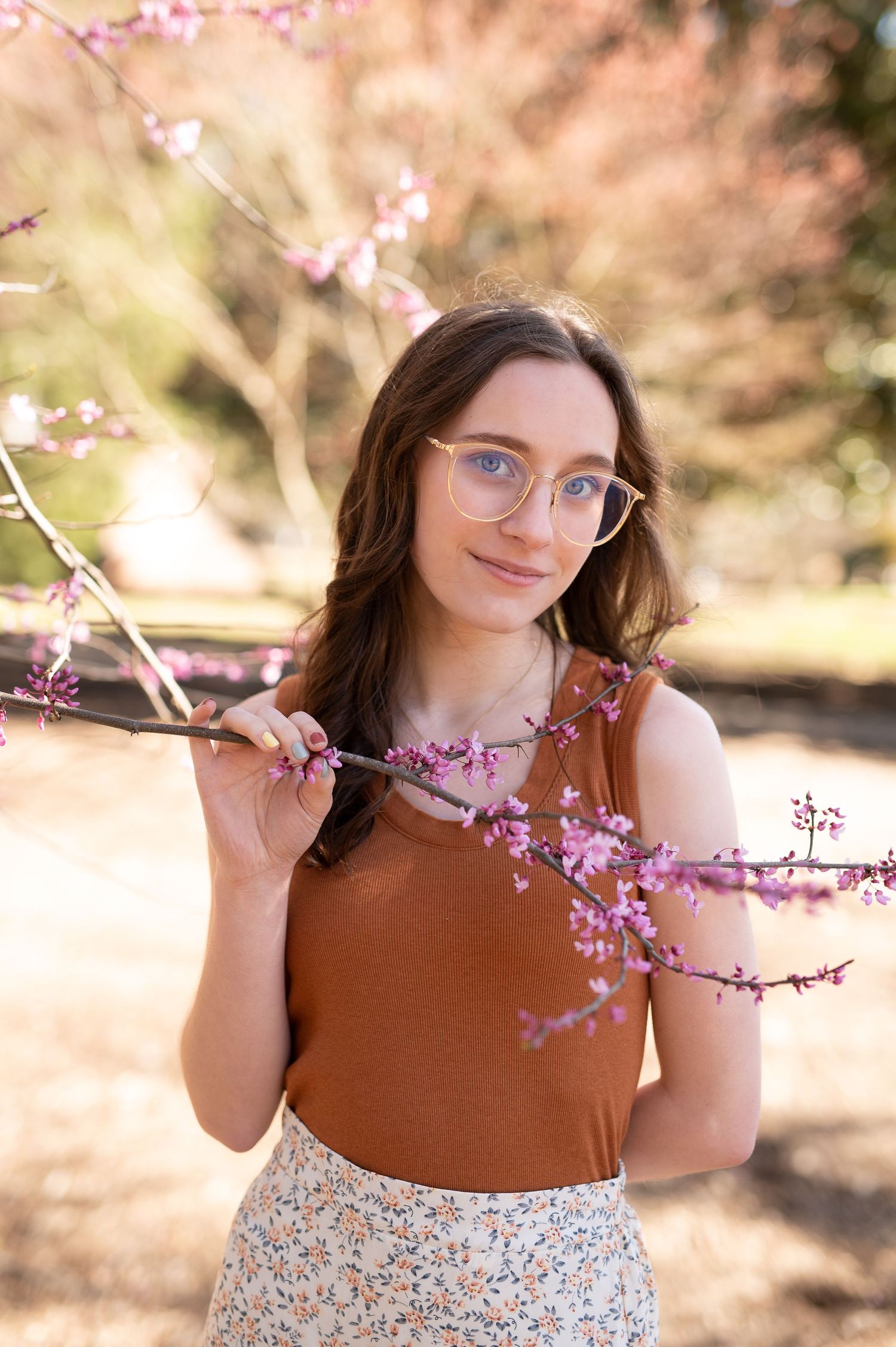 Spring portrait session with cherry blossoms and soft pink lighting.