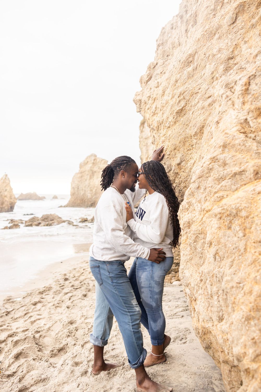 A romantic couple shares intimate moments against a sandy beach cliff backdrop in a series of connected photos.