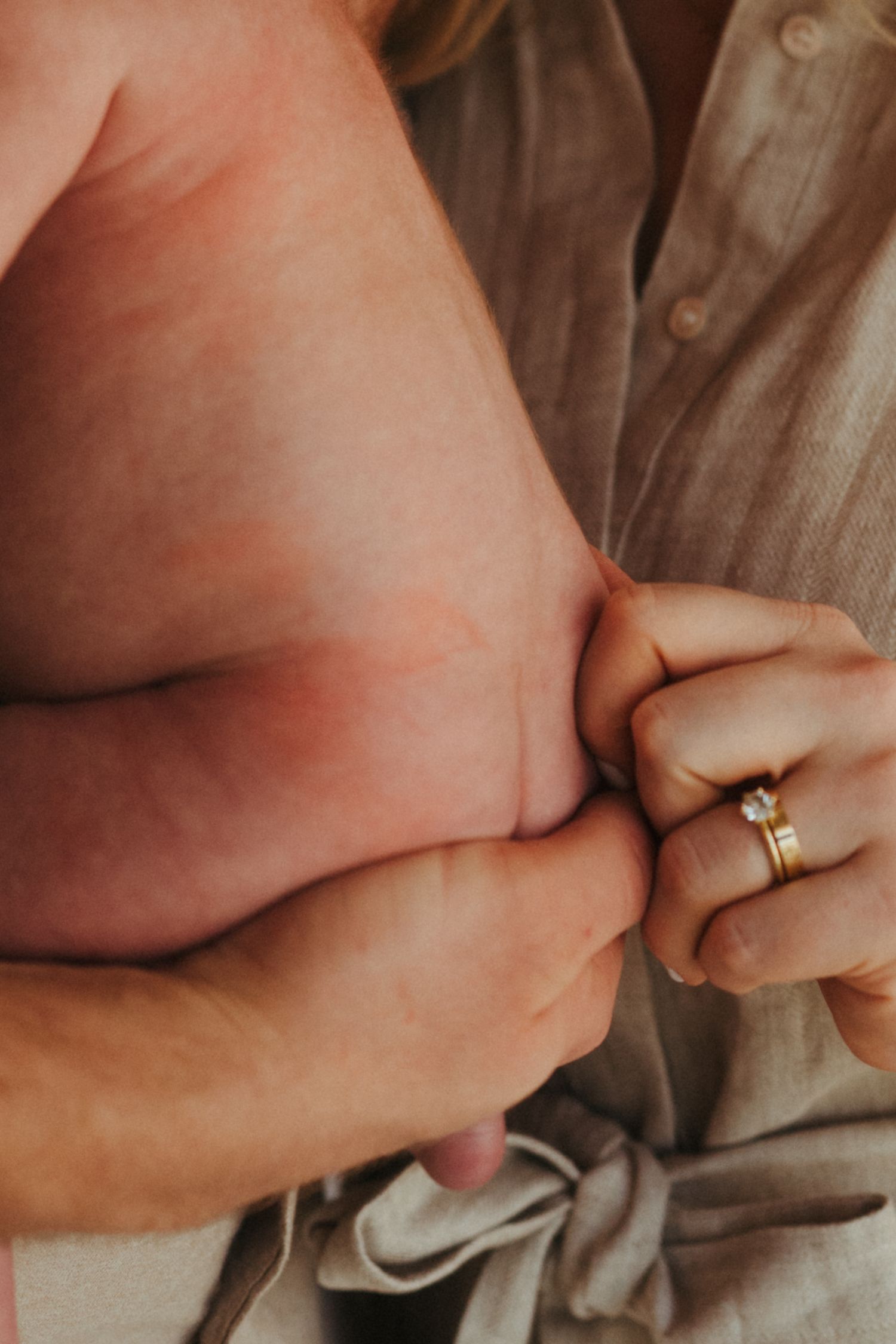 Close-up shots of hands with wedding rings intertwined against soft fabric.