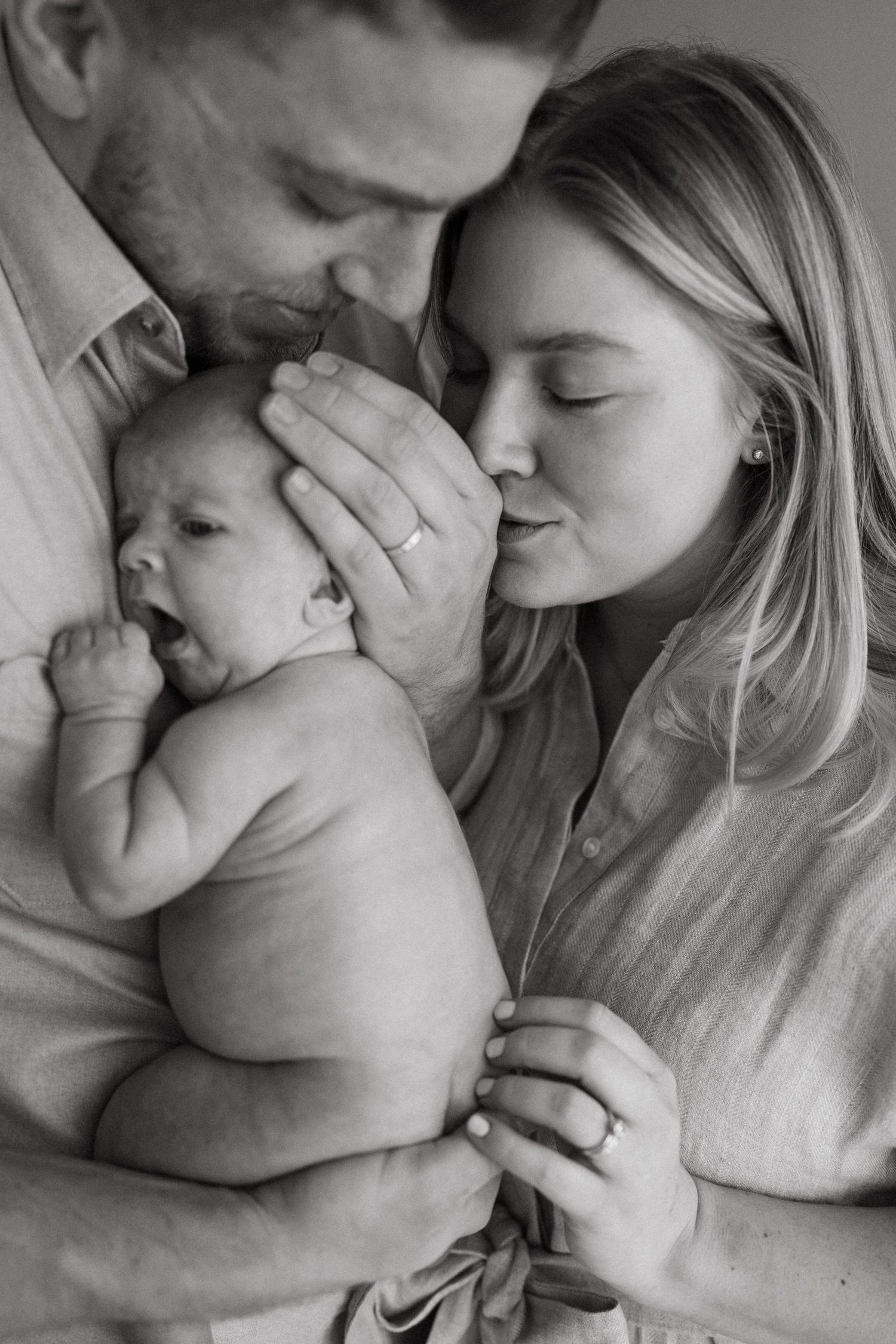 Black and white series capturing tender family moments with a newborn.