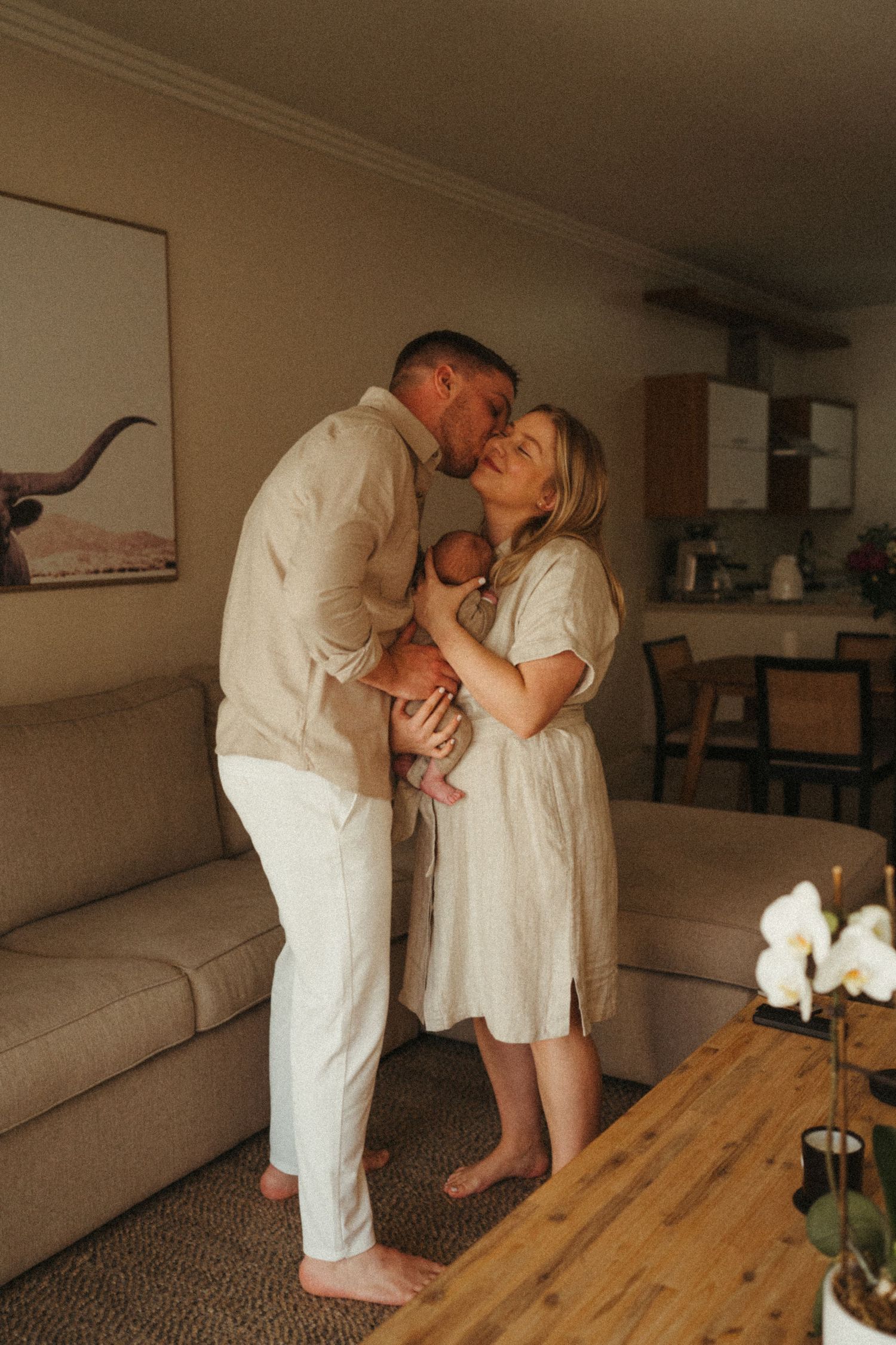 Intimate family photography session showing tender moments in a modern living room setting.