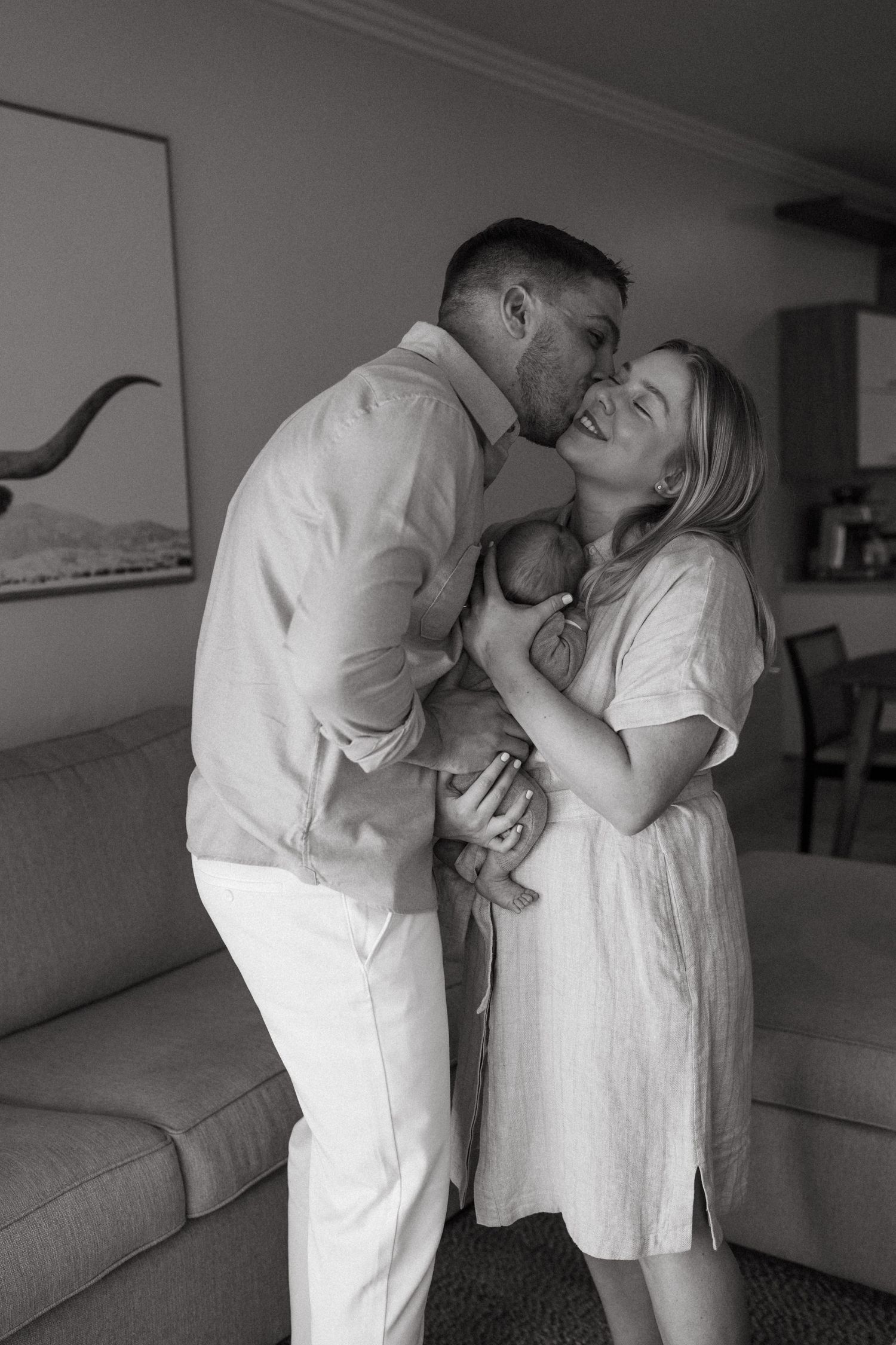 Black and white series capturing intimate family moments in a minimalist home interior.