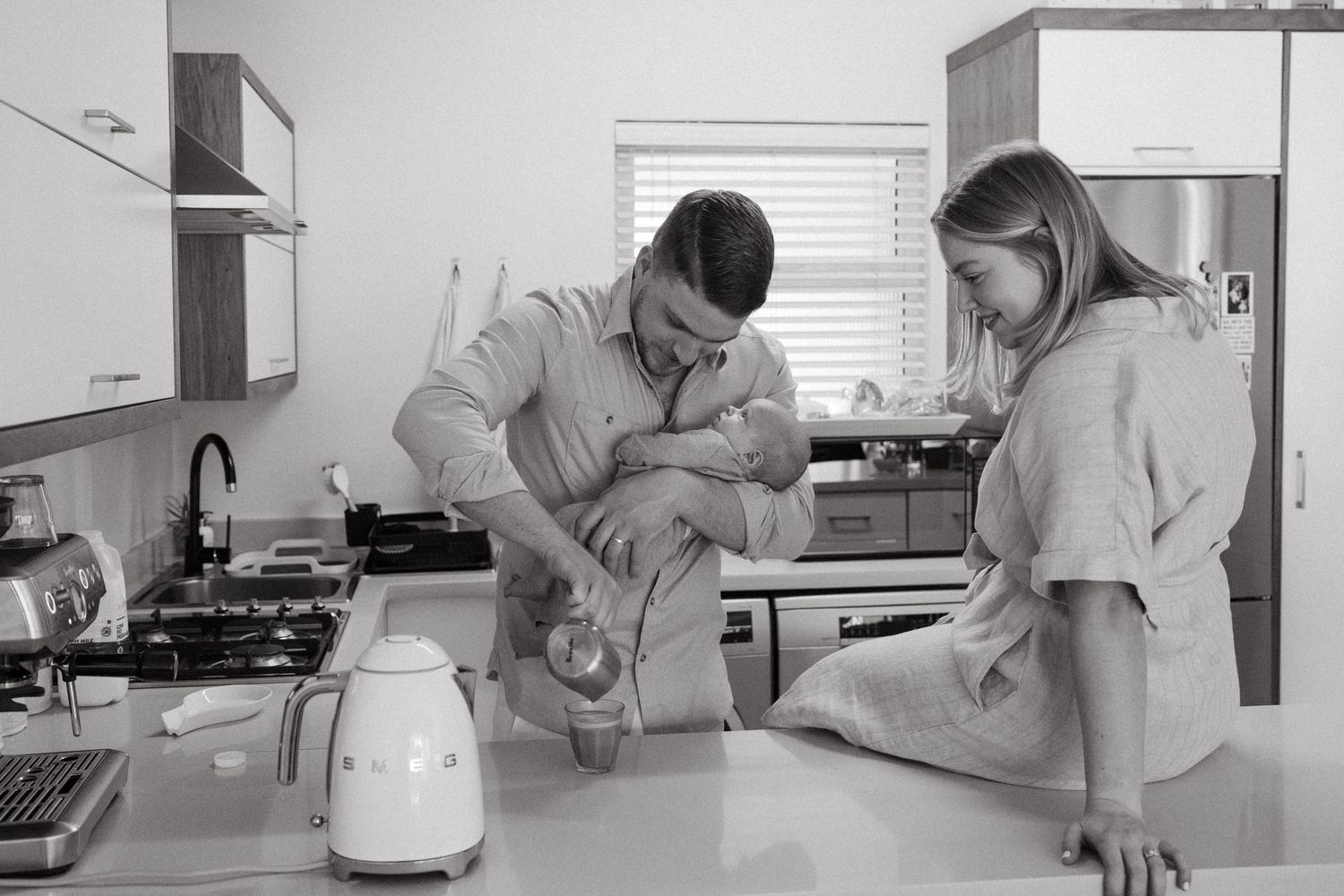 Black and white photo of kitchen scene with people preparing food.