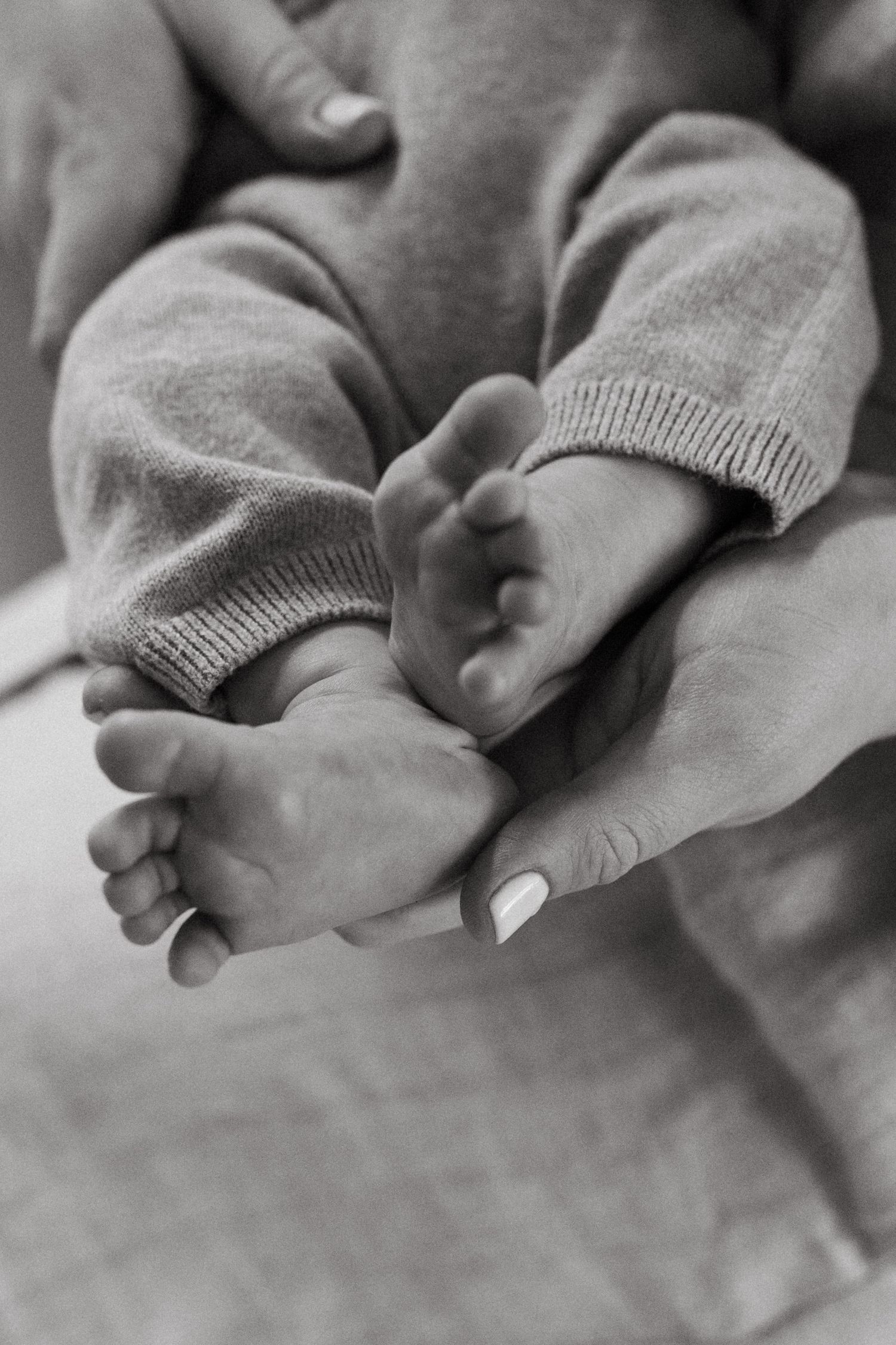 Close up black and white photo of hands clasped together.