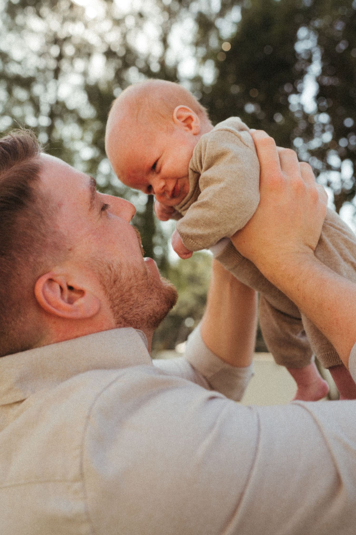 Intimate bonding moment between parent and baby in warm natural lighting.