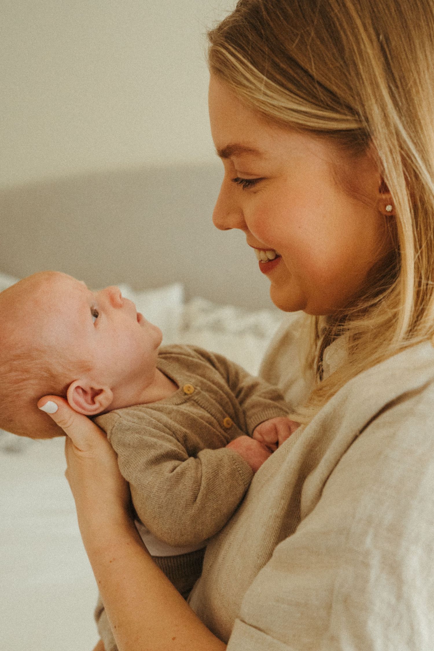 Tender moment between parent and newborn baby in warm natural lighting.