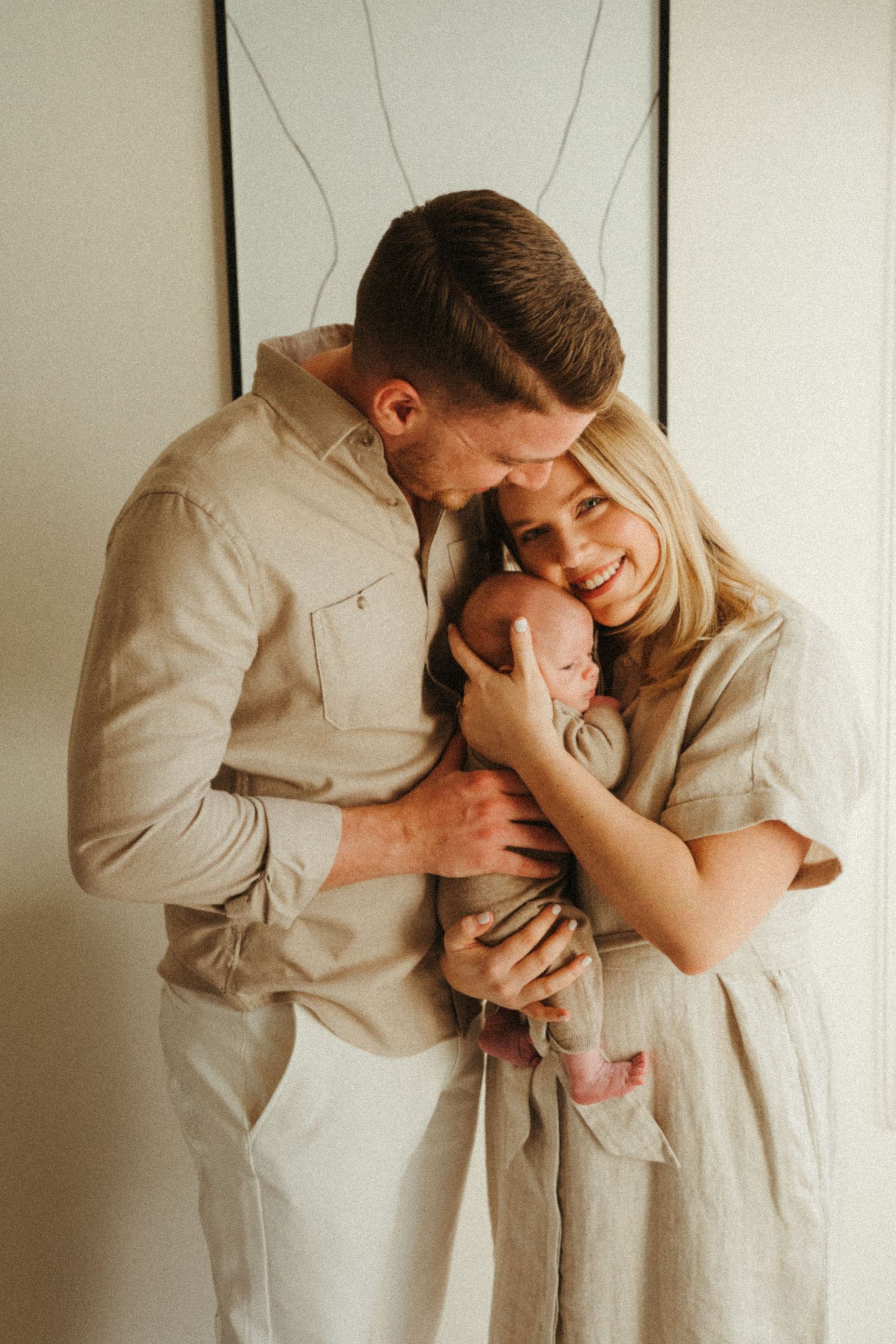 Family sharing intimate moment together in neutral toned clothing.